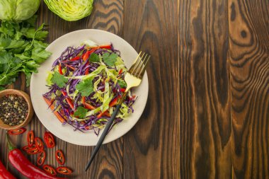 Mor lahana salatası, beyaz lahana, ahşap bir masada tabakta dolma biber. Taze sebze salatası. Yemek arkaplanı. Vejetaryen yemeği. Yukarıdan bak. Boşluğu kopyala.