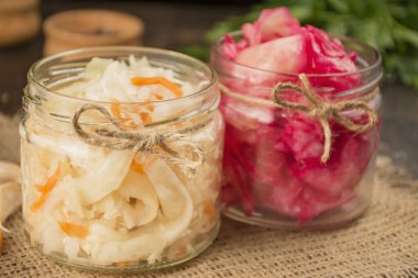 Havuçlu lahana turşusu ve küçük kavanozda pancar salatası. Ev yapımı yemek. Ekşi yemek. Sebze turşusu. Özellikli ürünler. Yan görünüm .