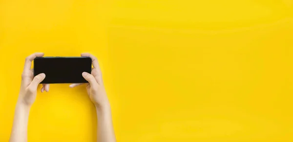 Hombre Sostiene Teléfono Inteligente Sus Manos Sobre Fondo Amarillo Estilo — Foto de Stock