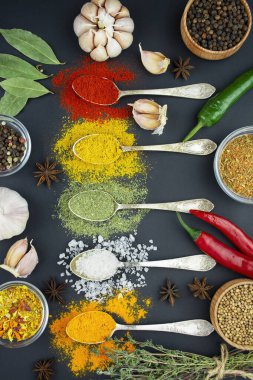 Karanlık bir masada çeşitli baharatlar ve otlar. Aşçılık geçmişi. Yukarıdan bak. Yemek yapmak için gerekli malzemeler. Masa arkaplan menüsü. Boşluğu kopyala.