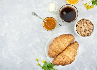 Taze kruvasan, reçel ve kahve ile Avrupa kahvaltısı. Işık masasında kahvaltı, üst manzara. Yemek arkaplanı. Boşluğu kopyala.