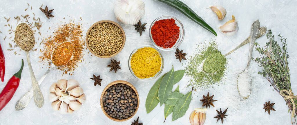 A variety of spices and herbs on a light table. Cooking background. View from above. Ingredients for cooking. Table background menu.