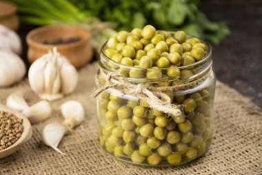 Cam kavanozda ev yapımı bezelye konservesi. Ev yapımı yemek. Mayalanmış yiyecek. Yan görünüm, yakın plan.