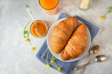 Taze kruvasan, reçel ve kahveyle kahvaltı. Işık masasında kahvaltı, üst manzara. Yemek arkaplanı. Yemek arkaplanı. Boşluğu kopyala.