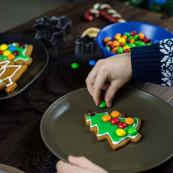 A child decorates cookies with candy