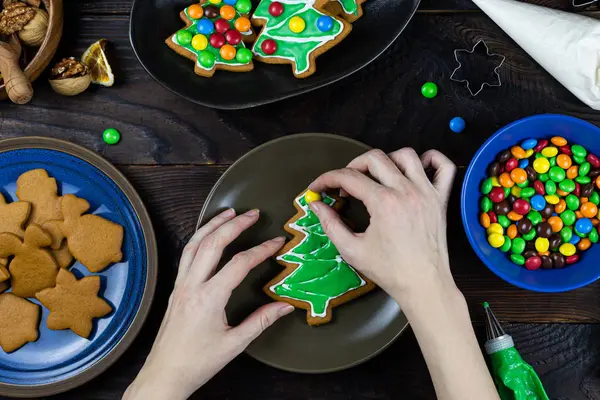 A hands decorates cookies with candy