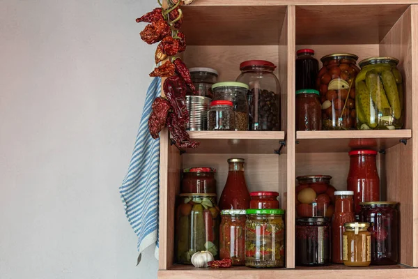 Homemade vegetables in jars on wooden shelves in the home pantry. Pickled food, as stocks from the autumn harvest, will be useful for self-isolation. Healthy healthy food from the garden.