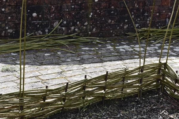 伝統的な手作りの庭のベッドの仕切りまたは編んだ柳から作られた縁 — ストック写真
