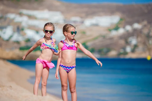 Sevimli küçük kızlar plaj tatil sırasında eğleniyor. İki çocuk Yunan tatile birlikte — Stok fotoğraf