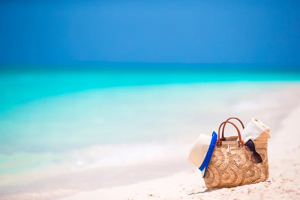 Acessórios de praia - saco de palha, fones de ouvido, avião de brinquedo e óculos de sol na praia — Fotografia de Stock