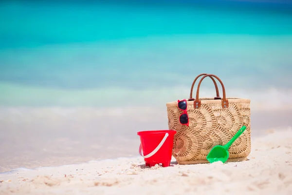 Beach accessories - straw bag, headphones, beach kids toys and sunglasses on the beach — Stock Photo, Image