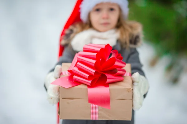 Primo piano scatola di Natale in mano di adorabile bambina in giorno d'inverno all'aperto — Foto Stock