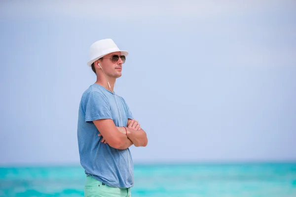 Felice giovane uomo godendo il tempo sulla spiaggia di sabbia bianca — Foto Stock
