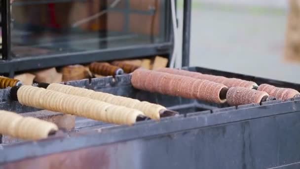 Pouliční jídlo na pražském trhu pod širým nebem. Proces výroby tradičních českých pekařských výrobků trdelnik. — Stock video