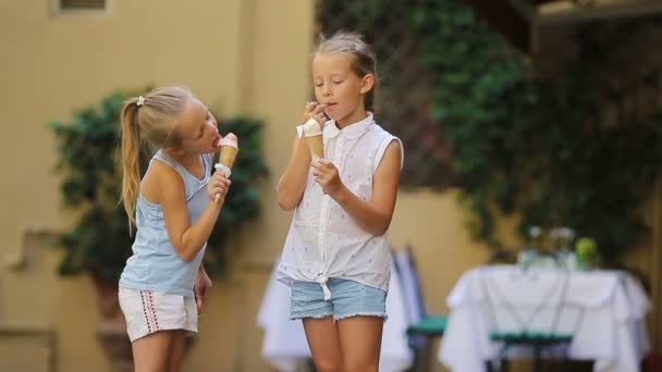 夏に屋外でアイスクリームを食べる愛らしい女の子。ローマのゲラテリア近くで本物のイタリアのジェラートを楽しむかわいい子供たち — ストック動画