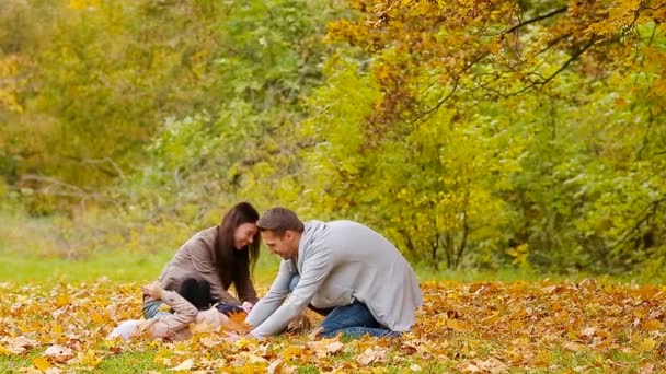 Jeune famille avec de petits enfants s'amusant dans le parc d'automne 