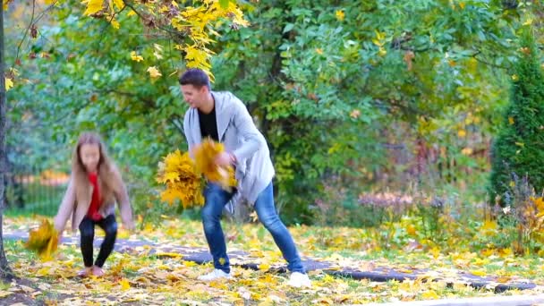 Adorables petites filles et heureux père avec mère profiter jour d'automne dans le parc d'automne en plein air. Vacances d'automne en famille 