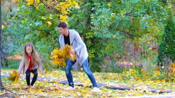 Imádnivaló kislányok és boldog apa és anya élvezze őszi nap a szabadban őszi parkban. Őszi családi nyaralás — Stock videók