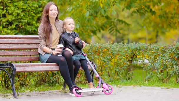 Очаровательная маленькая девочка с мамой наслаждаются осенним днем в осеннем парке на открытом воздухе — стоковое видео