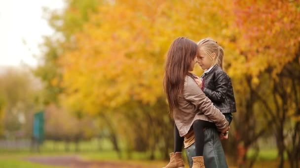 Schattig meisje met moeder herfstdag in herfst park buitenshuis genieten van — Stockvideo