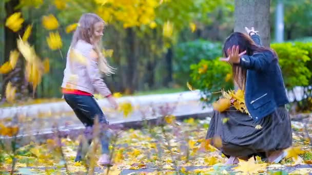 Ładny mały dziewczyna i szczęśliwa matka cieszyć się dzień jesieni w jesienny park na zewnątrz. Jesienne wakacje — Wideo stockowe