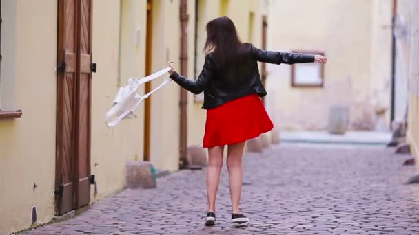 유럽의 오래 된 거리에 사는 행복 한 젊은 도시 여성. 유럽의 황량 한 거리를 걷고 있는 백인 관광객. — 비디오