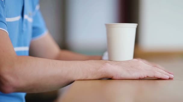 Close-up van een man met koffie in een café. Een man die de tijd in de gaten houdt. Wazige achtergrond, horizontaal. — Stockvideo