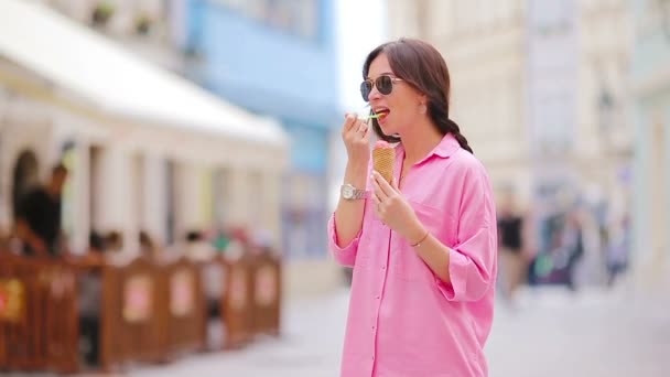 Giovane modello femminile mangiare cono gelato all'aperto. Concetto estivo - woamn con gelato dolce a giorno caldo — Video Stock
