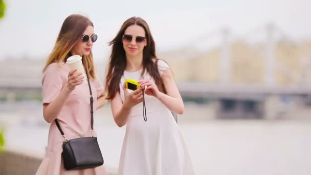 Chicas caucásicas haciendo selfie fondo puente grande. Jóvenes amigos turistas que viajan de vacaciones al aire libre sonriendo felices . — Vídeo de stock