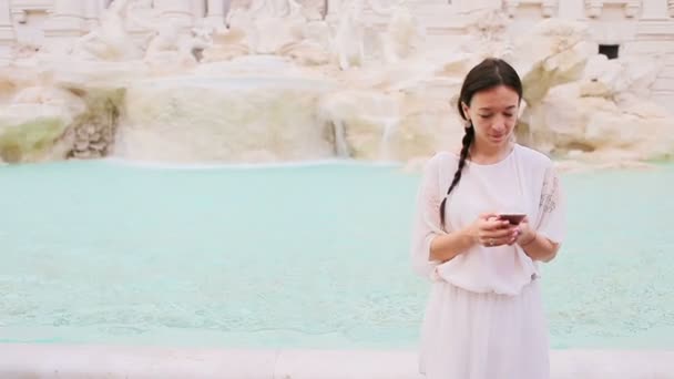 Jonge vrouw met slimme telefoon in de buurt van beroemde Fontana di Trevi — Stockvideo