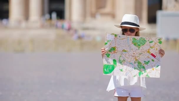 Schattig klein meisje met toeristische kaart op St. Peters Basiliek plein, Italië. Happy Toodler kid genieten van Italiaanse vakantie in Europa. — Stockvideo