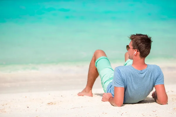 Happy young man enjoying time on white sandy beach — Stock Photo, Image