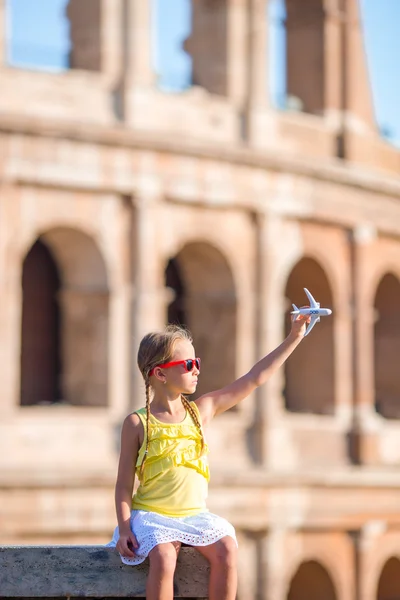 Adorable girl with small toy model airplane background Colosseum in Rome, Italy — Stock Photo, Image