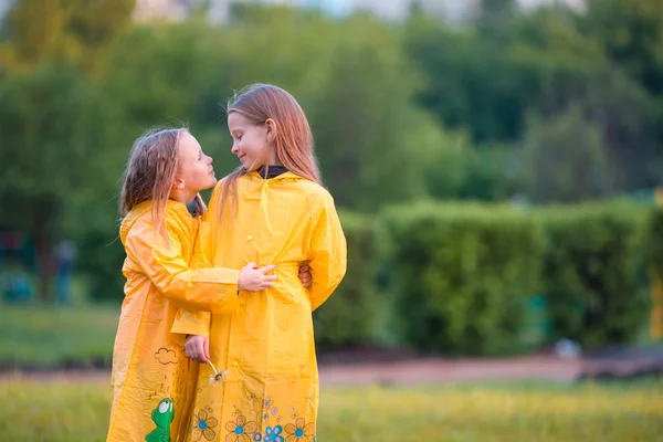 Adorable little girls under the rain on warm autumn day — Stock Photo, Image