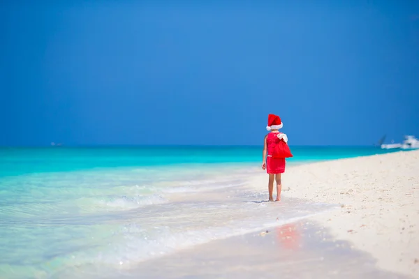 圣诞海滩度假期间戴圣诞礼帽的可爱小女孩 — 图库照片