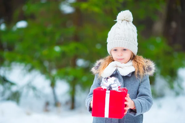 Entzückendes kleines Mädchen mit Weihnachtsschachtel Geschenk im Winter Tag im Freien — Stockfoto