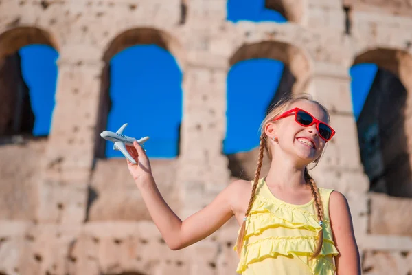 Adorable girl with small toy model airplane background Colosseum in Rome, Italy — Stock Photo, Image