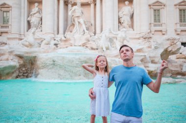 Mutlu aile Trevi Çeşmesi, Roma, İtalya iyi şanslar için sikke trowing. Küçük kız ve baba geri dönmek için bir dilek yapıyor.