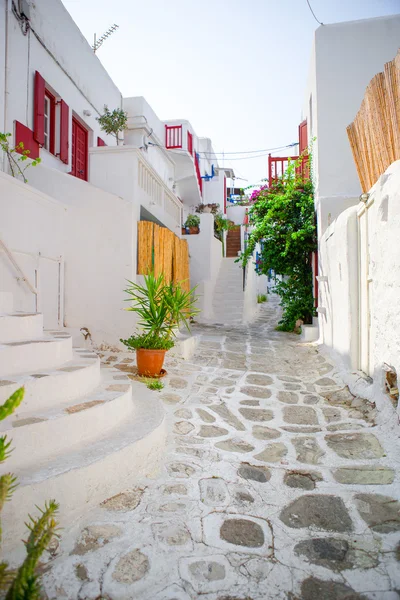 As ruas estreitas com varandas azuis, escadas, casas brancas e flores em bela aldeia na Grécia. Bela arquitetura exterior do edifício com estilo cíclico em Mykonos — Fotografia de Stock