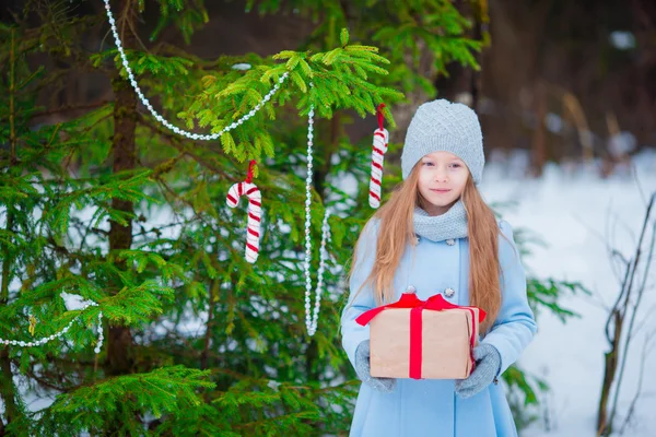 Adorable petite fille avec cadeau de boîte de Noël en plein air jour d'hiver — Photo