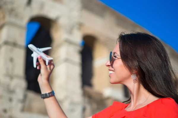 Menina com pequeno modelo de brinquedo avião fundo Coliseu em Roma, Itália — Fotografia de Stock