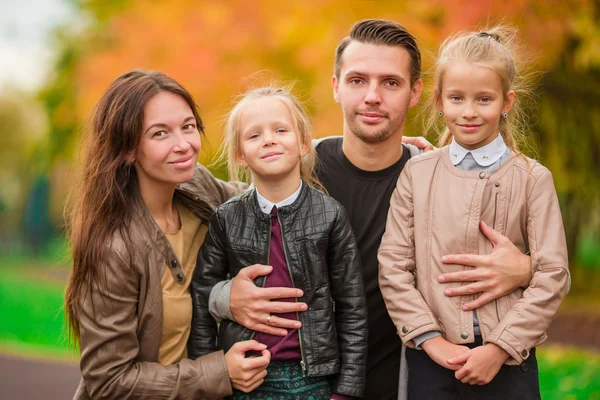Mladá rodina s malými dětmi v podzimním parku na slunečný den — Stock fotografie