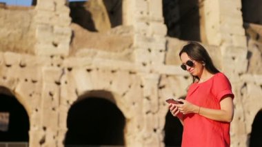 İtalya, Roma 'da kolezyum önünde akıllı telefonla mesaj yollayan bir kadın. Kız İtalya 'da tatilde.