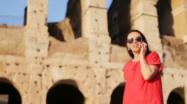 Mutlu Kafkasyalı kız, İtalya 'nın Roma şehrinde dünyanın en popüler yeri olan Kolezyum' un önünde cep telefonuyla konuşuyor. Kız İtalya 'da tatilde.