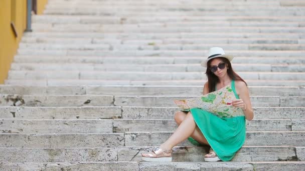 Mulher bonita olhando para o mapa da cidade turística em Roma, Itália. Menina feliz desfrutar de férias italianas férias na Europa . — Vídeo de Stock