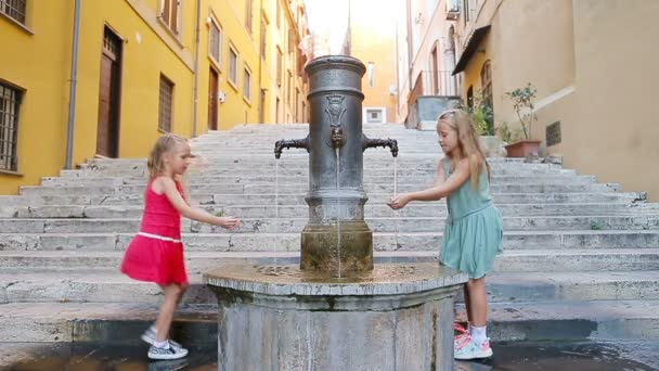 Roma, İtalya 'da sıcak bir yaz günü sokak çeşmesinden su içen sevimli kızlar. — Stok video