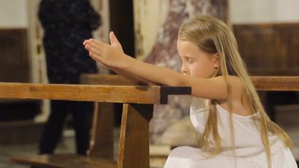 Liten flicka prisar i kyrkan — Stockvideo