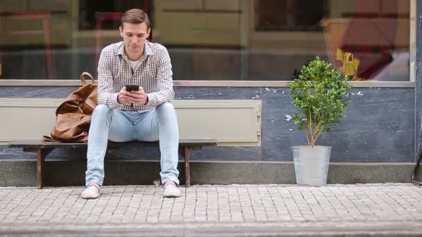 Hombre enviando un mensaje por su teléfono inteligente al aire libre en la calle. Hombre usando teléfono inteligente móvil . — Vídeo de stock