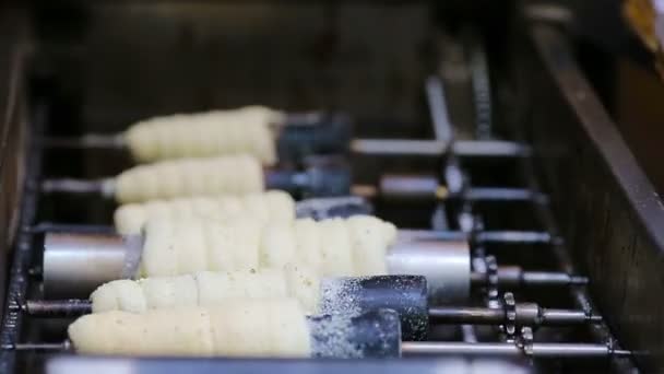 Уличная еда на открытом рынке. Процесс изготовления традиционных чешских хлебобулочных изделий Трдельник . — стоковое видео