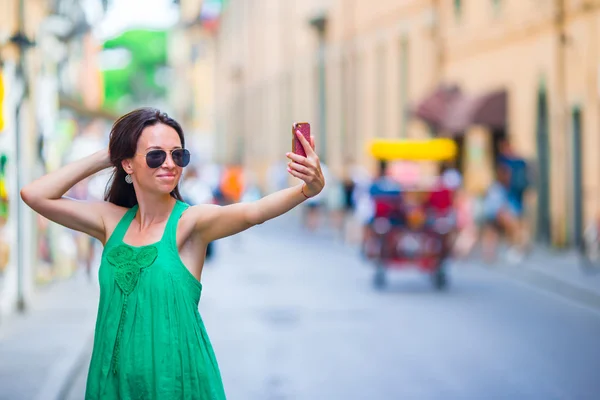 Vrouw nemen selfie door haar smartphone in de stad. Jonge aantrekkelijke toerist die buiten foto 's maakt in de Italiaanse stad — Stockfoto